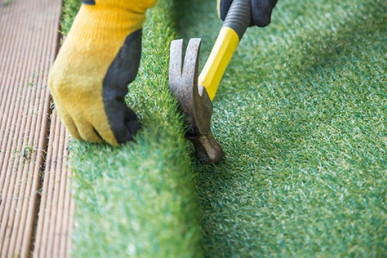 Hammering down artificial turf onto wooden decking